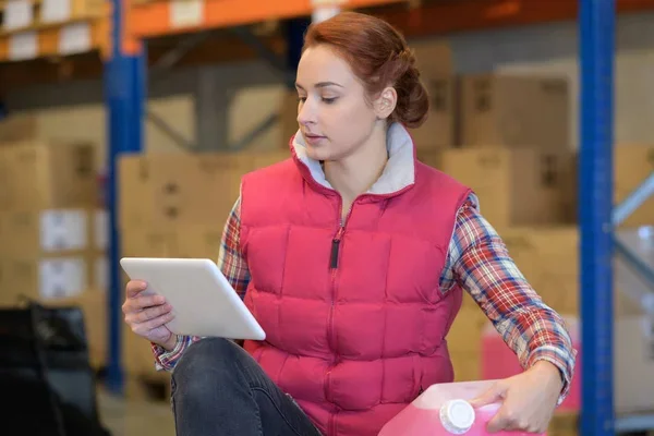 Mujer en almacén sosteniendo contenedor
