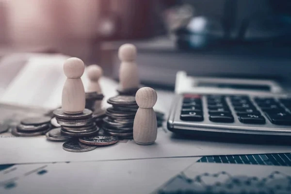 empleado dejando calculadora en primer plano con monedas y fichas, después de realizar un flujo de caja
