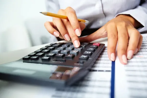 hombre calculando el flujo de caja de su negocio utilizando una calculadora