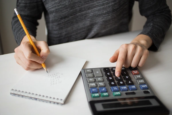 empresario calculando el activo circulante, apoyándose con una calculadora