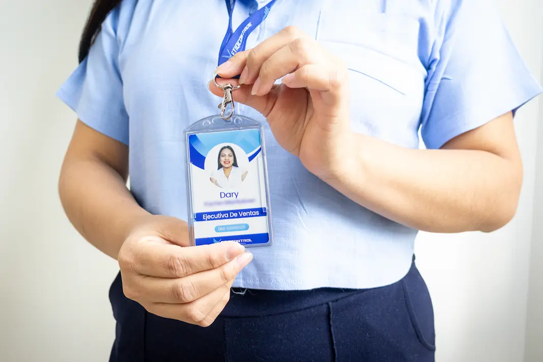 Persona sosteniendo un fotocheck de identificación.