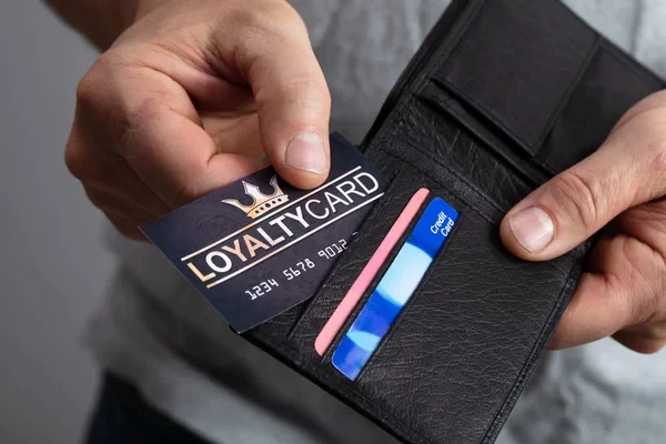 cliente en primer plano mostrando su tarjeta del programa de fidelización de clientes