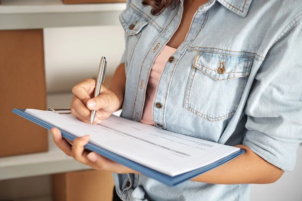 primer plano de mujer calculando el índice de rotación de inventario con papel y lapiz
