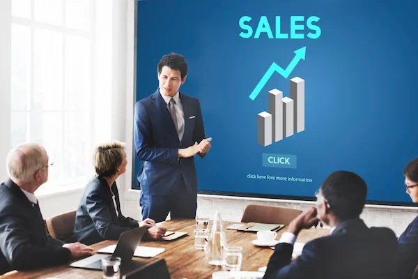 colaborador realizando una presentación de ventas frente a sus compañeros de trabajo