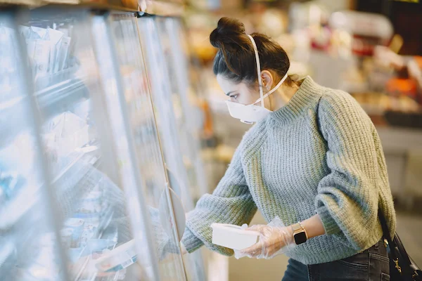 mujer revisando productos congelados en supermercado