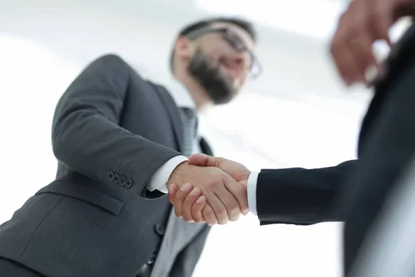 compañeros de trabajo estrechando las manos en oficina